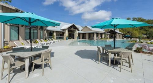 Apartments in Spring, TX - Pool and Patio Area with Lounges and Tables